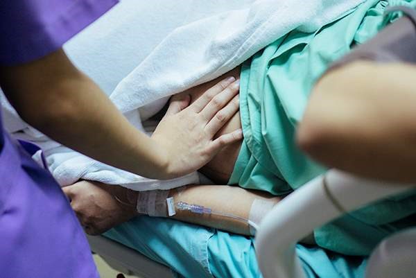 How does pain after childbirth affect the risk of postpartum hemorrhage?